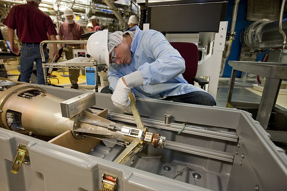 National Ignition Facility (NIF) engineer Erik Boehm inspects the ignition target insertion cryostat, or ITIC, the system that holds and cools the NIF target to cryogenic temperatures of minus 426 degrees Fahrenheit. The two Y-shaped arms form a shroud around the cold target to protect it until they