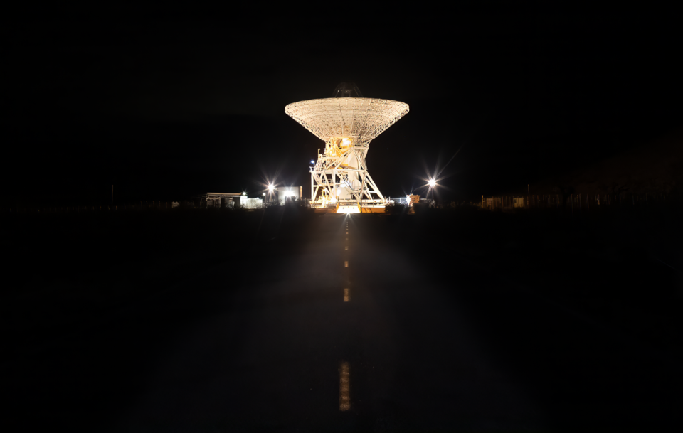 A 112-foot (34-meter) antenna glows from within a nighttime scene at the Goldstone Deep Space Communications Complex near Barstow, California, in September 2025. Goldstone is part of NASA’s Deep Space Network (DSN), which operates three complexes around the globe that support communications with doz