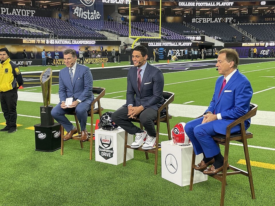 Rece Davis, David Pollack, and en:Nick Saban, next to the College Football Playoff National Championship Trophy, doing pre-game analysis from the sideline of the 2023 College Football Playoff National Championship at SoFi Stadium in Inglewood, California.