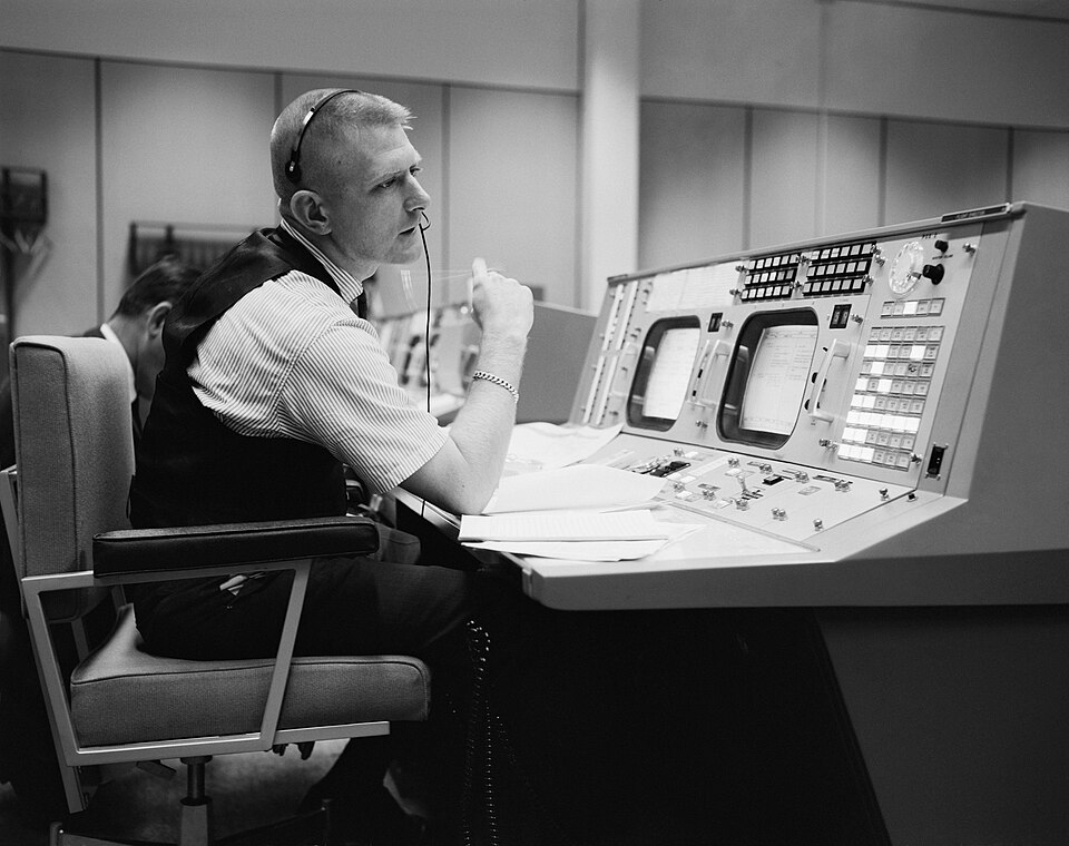 Eugene F. Kranz, flight director, is shown at his console on May 30, 1965, in the Mission Operations Control Room in the Mission Control Center at Houston during a Gemini-Titan IV simulation to prepare for the four-day, 62-orbit flight. (NASA Photo S-65-22203.)