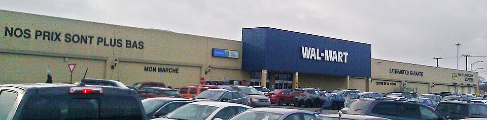 Walmart store of Galeries Rive Nord with old logo photographed in Repentigny, Quebec, Canada  By 2018-19, the store was renovated and phaseout of the old logo within the exterior happened 2018.  The store was Woolco from the mall's 1975 inauguration until 1994.