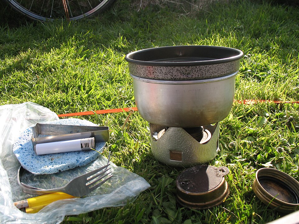 Mini Trangia stove in use, consisting of an alcohol burner and 0.8l pot with lid that also acts as nonstick frying pan.

The pot simmer ring and lid are in the foreground, and handle in the background behind a lighter.