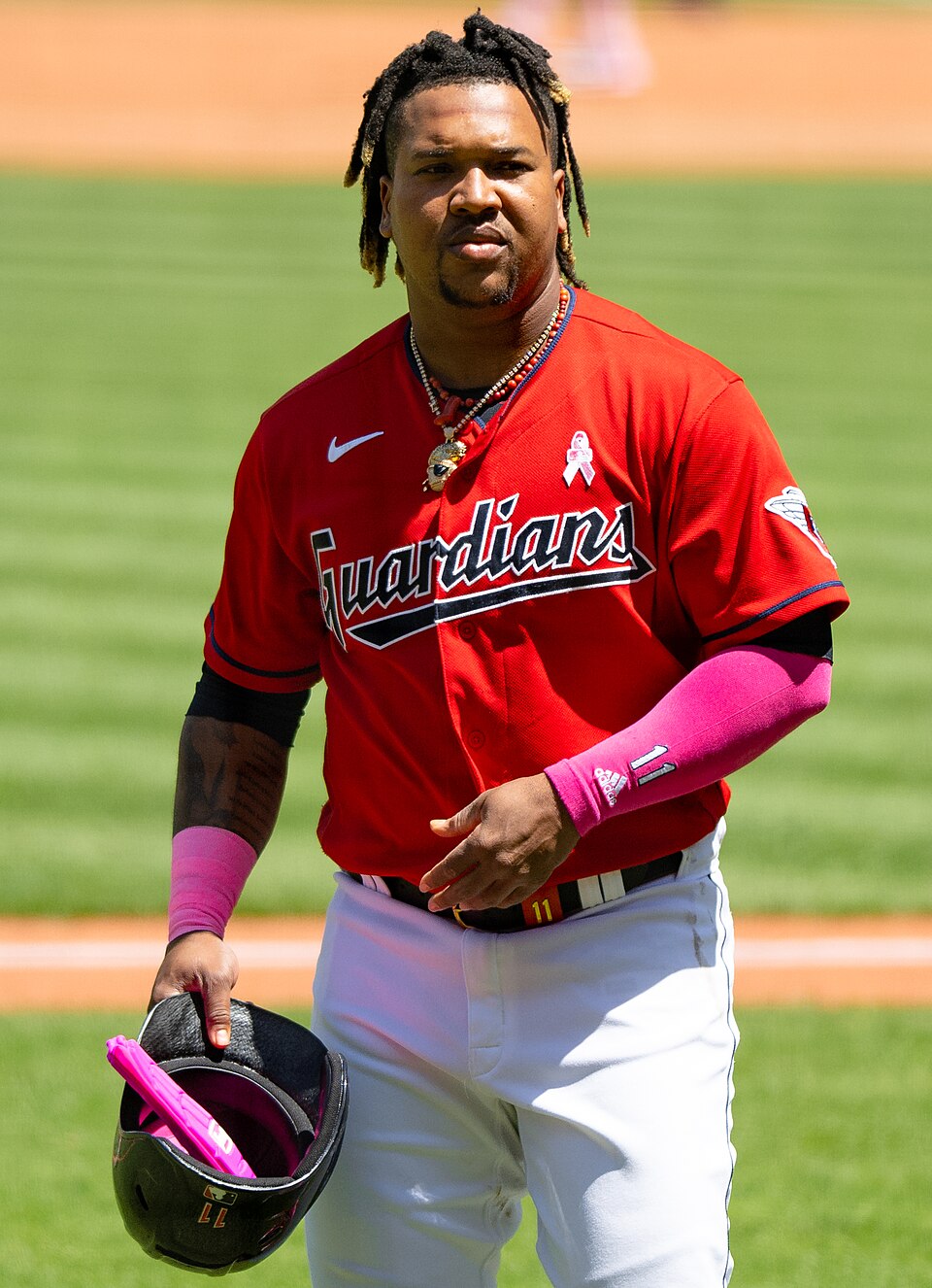 Jose Ramirez holds his batting helmet and walks toward the dugout at Progressive Field during a May 2023 game with the Cleveland Guardians.