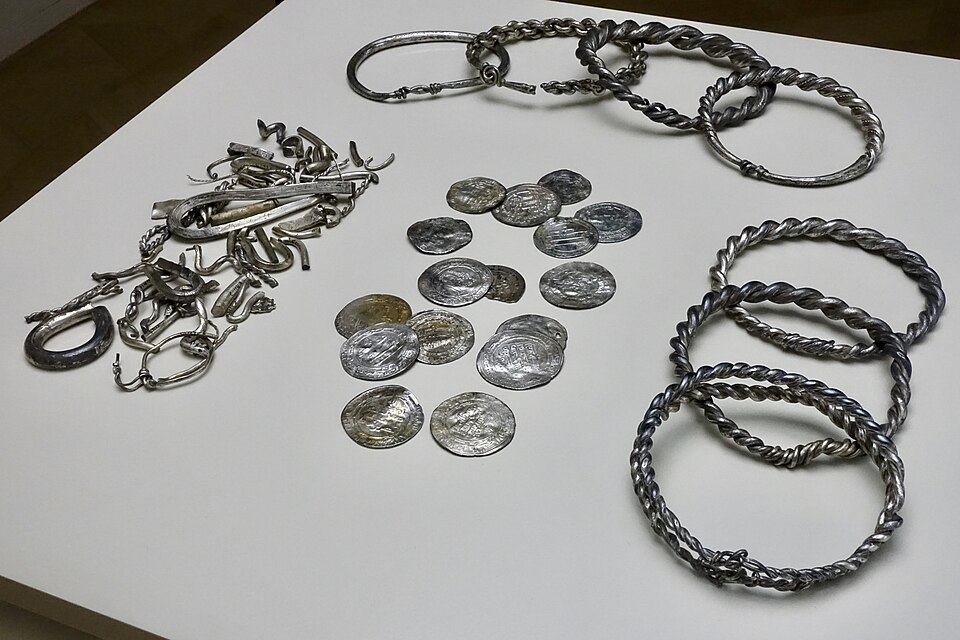 01. Silver hoard (in Norwegian: sølvskatt) found in 1844 at Teisen Farm in Oslo, Norway: seven arm rings (probably made from melted down coins), one ingot, many pieces of hack-silver, 16 whole and many pieces of  Arabian and Persian (Kufic) coins. The newest of the silver coins was struck in AD 919.